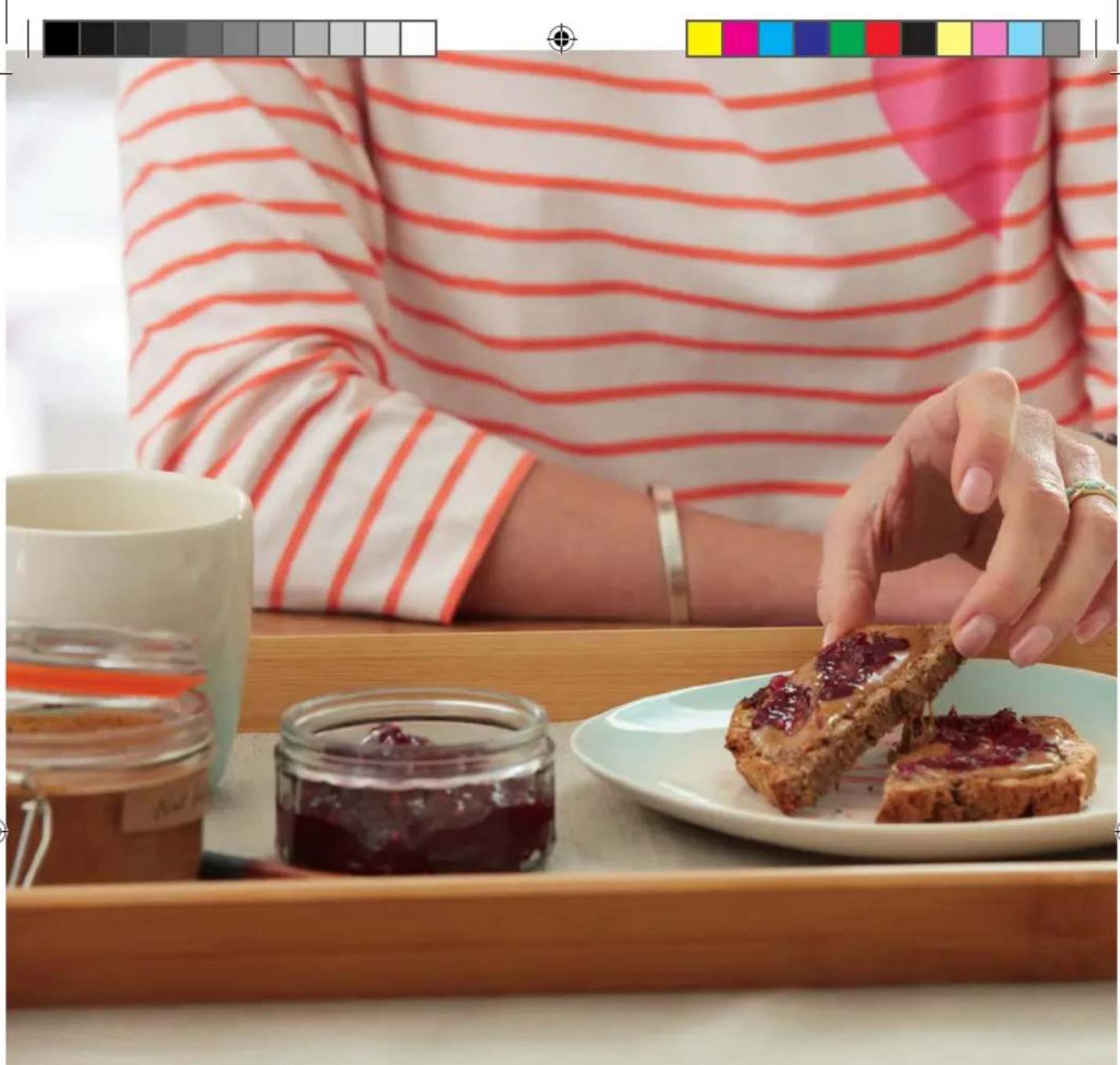 Person in striped shirt sharing a slice of jam with chocolate paste on a tray, with glass jar and coffee cup nearby (no text or symbols visible)