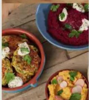 Three colorful dishes on a wooden surface, including bread, sautache, and red sauce (no visible text or labels)