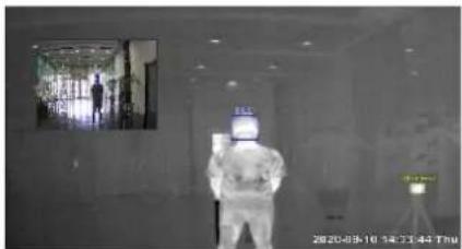 Thermal image showing a person in full protective suit with temperature reading 2820-09-10 14:33:44 THU, with background signage and window view.