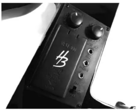 Close-up of a black electronic device with control knobs and a logo (no readable text or symbols beyond branding)
