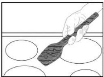 Illustration of a hand using a spatula to clean circular shapes on a surface (no text or symbols)
