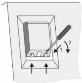 Diagram showing a tool interacting with a rectangular box containing small objects, labeled with arrows and numbered parts.