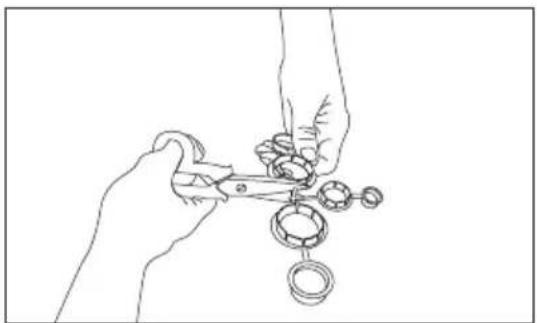 Line drawing of hands using scissors to cut mechanical parts (no text or symbols).