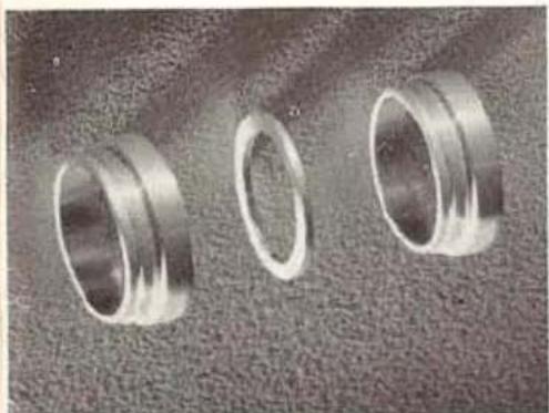 Three metallic ring rings arranged on a textured surface (no text or symbols visible)