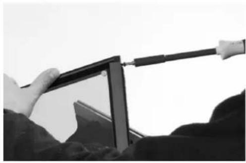 Person using a computer monitor to adjust or install a cable (no visible text or symbols)