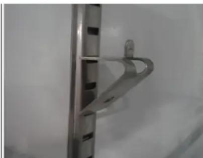Close-up of a metallic bracket with a curved handle and mounting holes (no text or symbols visible)