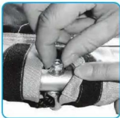 Close-up of hands adjusting a mechanical component with a metallic fitting (no visible text or symbols)
