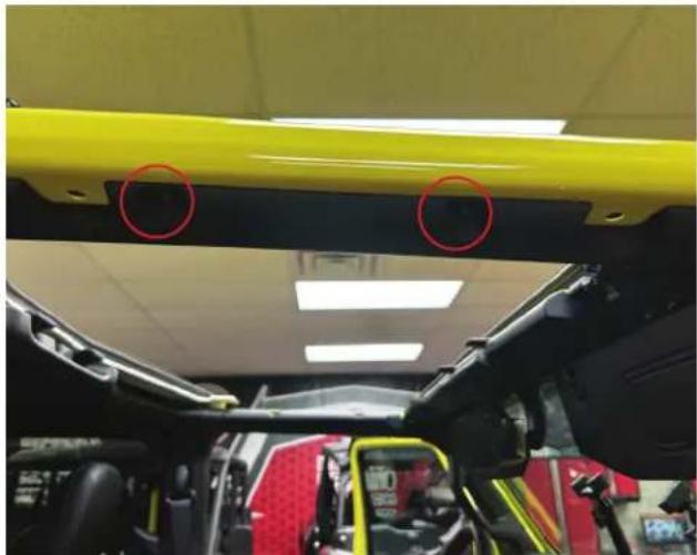 Interior view of a vehicle showing a yellow safety guard with two red-circled points, no visible text or symbols.