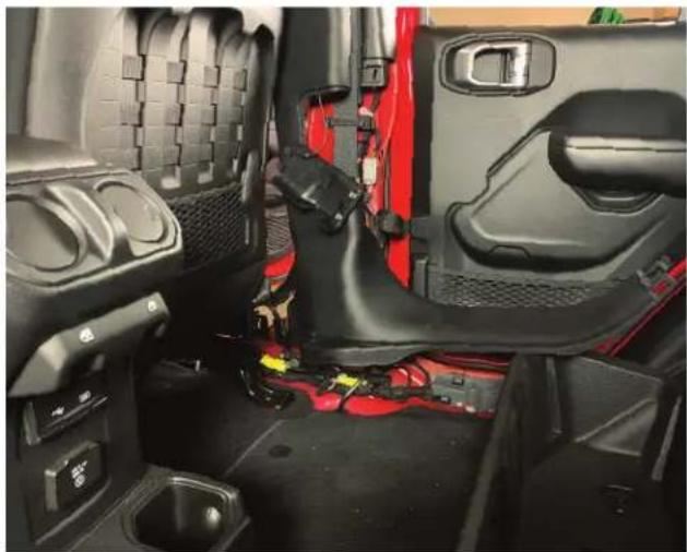 Interior view of a vehicle showing red seat, black seats, and wiring (no visible text or symbols)