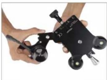 Close-up of hands holding a black handheld device with multiple circular components (no visible text or symbols)
