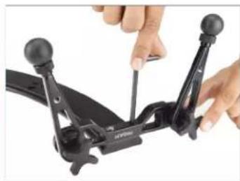 Close-up of hands operating a black mechanical device with two articulated arms (no visible text or symbols)