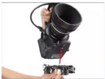 Person using a professional camera to adjust or install a camera lens (no visible text or symbols)
