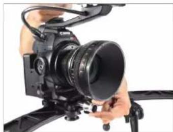 Close-up of a professional video camera with a lens mounted on a tripod (no visible text or symbols)