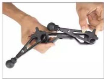 Close-up of hands holding a black mechanical clamp or lever (no text or symbols visible)