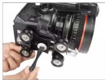 Close-up of a hand using a camera to adjust the lens and buttons (no visible text or symbols)