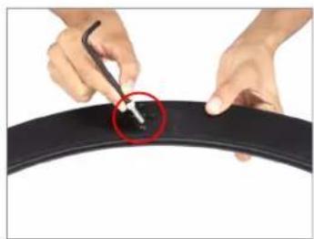 Close-up of hands using a tool to mark a black tire with a red circle highlighting the center (no text or symbols visible)
