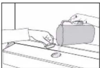 Line drawing of hands pouring liquid onto a surface with a small circular object (no text or symbols)