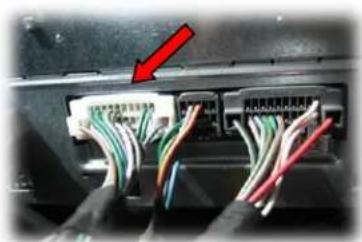 Close-up of a cable connector with visible wiring and a red arrow pointing to a component, likely indicating a power or signal connection.
