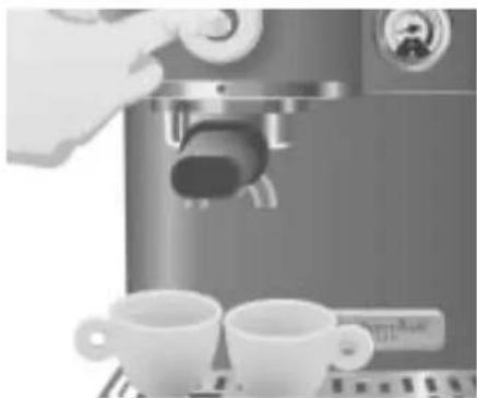 Close-up of a hand using a espresso machine with two cups on a tray (no visible text or symbols)