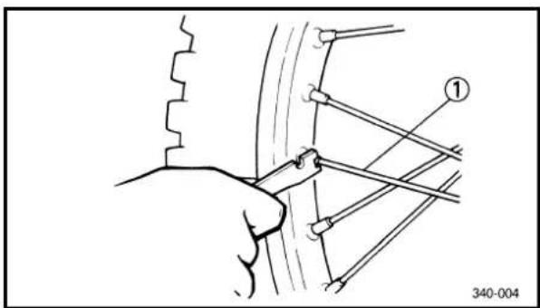 Technical diagram showing a hand holding a tool interacting with a car wheel, labeled with number 1 and reference number 340-004.