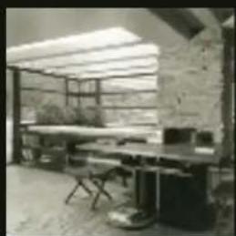 Interior view of a modern office or study room with bookshelves, tables, and chairs under a skylight (no visible text or symbols)