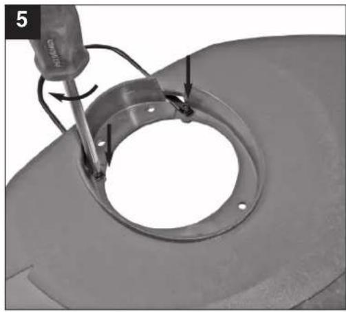 Close-up of a mechanical component with a tool inserted, showing a circular opening and mounting holes.