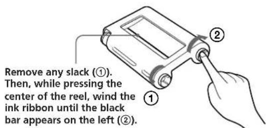 Remove any slack (①). Then, while pressing the center of the reel, wind the ink ribbon until the black bar appears on the left (②).