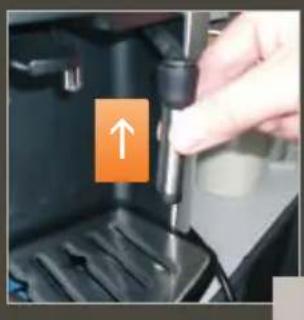 Close-up of a hand inserting a plug into a device component, with an orange arrow pointing to the plug (no text or symbols visible).
