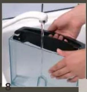 Close-up of hands cleaning a transparent container with a black lid. No text or symbols visible.