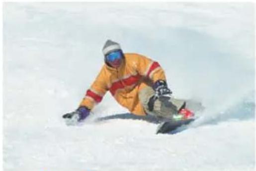 Snowboarder in orange jacket carving a snowboarder on a snowy slope (no text or symbols visible)