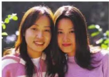 Two smiling young women outdoors, one in pink jacket, the other in purple jacket (no text or symbols visible)