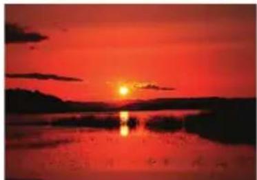 Sunset over a calm lake with silhouetted hills and reflections in the water (no text or symbols)