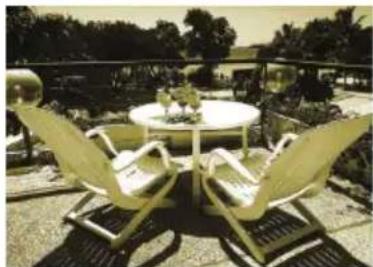 Outdoor patio scene with a round table, three folding chairs, and garden background (no visible text or symbols)