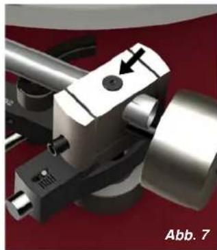 Close-up of a mechanical component with a black arrow pointing to a circular feature, labeled 'Abb. 7' at bottom right (no readable text or symbols on the object itself)