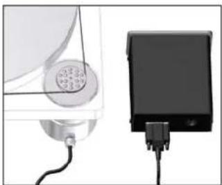 Two electronic devices: a circular device with a grid and connected cable, and a rectangular device with a plug inserted (no visible text or symbols)