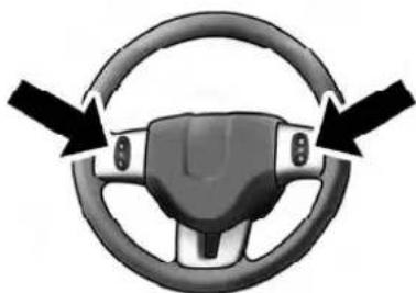 Interior view of a car steering wheel with directional arrows indicating clockwise motion (no text or symbols)