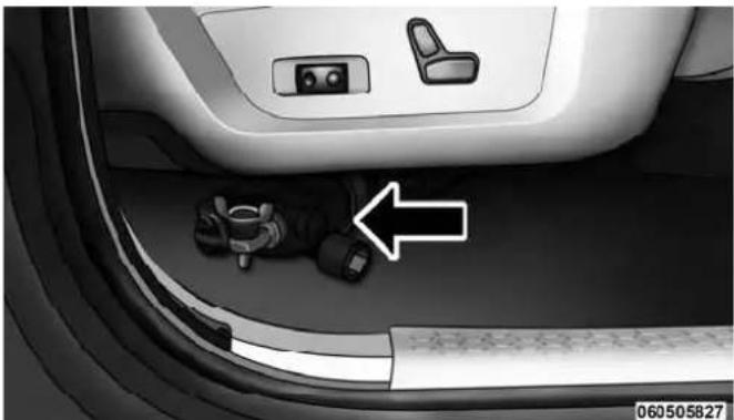Interior view of a car showing seatbelt and dashboard components with an arrow pointing to a small vehicle (no text or symbols visible)