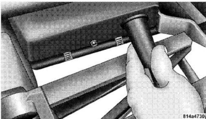 Close-up of a hand using a tool to adjust or install a mechanical component (no visible text or symbols)