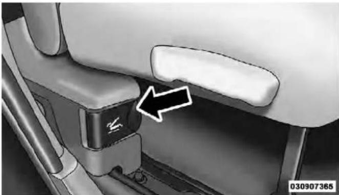 Close-up of a car seatbelt buckle mechanism with an arrow pointing to the side panel (no text or symbols visible)