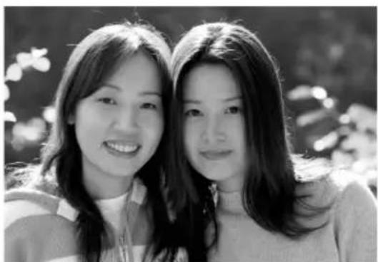 Black-and-white portrait of two smiling young women outdoors, no text or symbols visible.