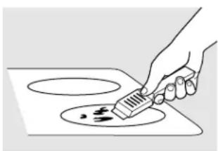Hand using a brush to clean or store food on an induction cooktop (no text or symbols visible)
