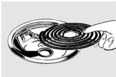 Illustration of a hand inserting a coiled spring into a circular component (no text or symbols)