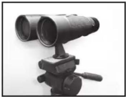 Black-and-white photo of a binoculars mounted on a tripod stand (no visible text or symbols)
