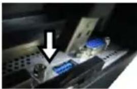 Close-up of a mechanical device with blue components and a white arrow pointing to a component (no visible text or symbols)