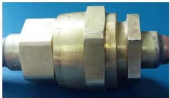 Close-up of a metallic mechanical component with hexagonal flanges and stepped shaft (no visible text or symbols)