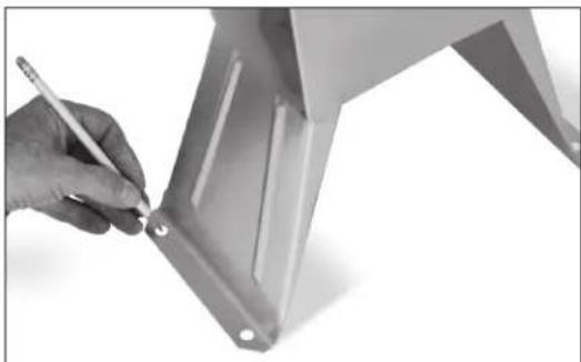 Close-up of a hand holding a pen next to a metallic metal bracket (no text or symbols visible)