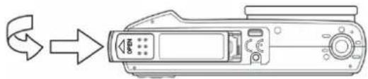 Line drawing of a digital camera with an arrow indicating rotation (no text or symbols)