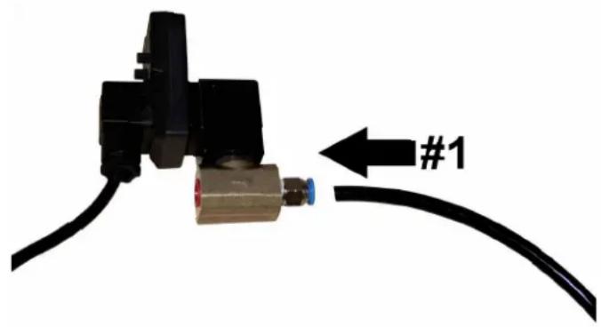 Close-up of a black mechanical component connected to a black cable, with a blue connector labeled #1 pointing left (no text or symbols on the main subject)