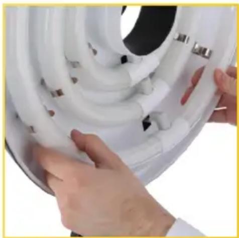 Close-up of hands installing or adjusting white plastic hose components on a circular device (no text or symbols visible)