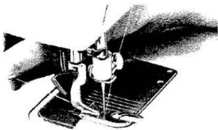 Gros plan sur l'aiguille d'une machine à coudre piquant un tissu (aucun texte ou symbole visible).